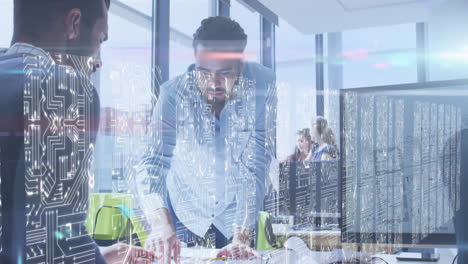 screens with microprocessor connections against diverse two male colleagues discussing at office