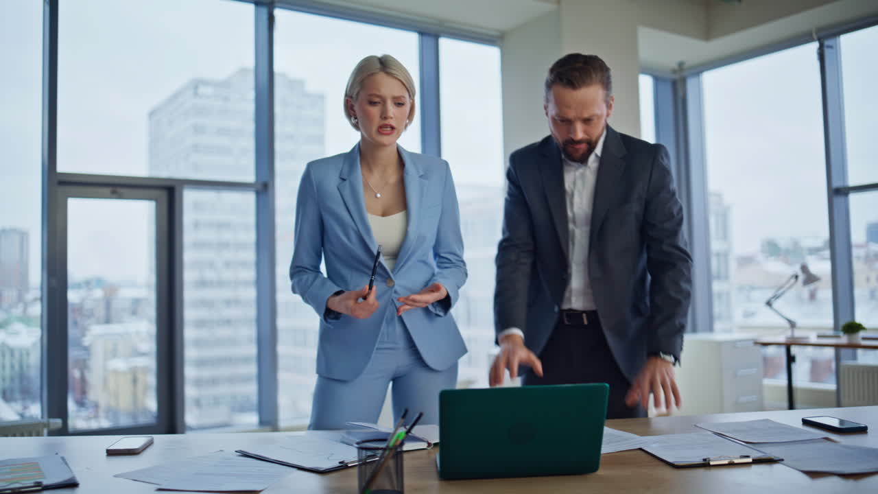 Office colleagues looking laptop together in panoramic windows agency closeup