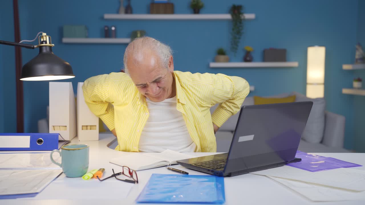 Home office worker old man has lower back pain.