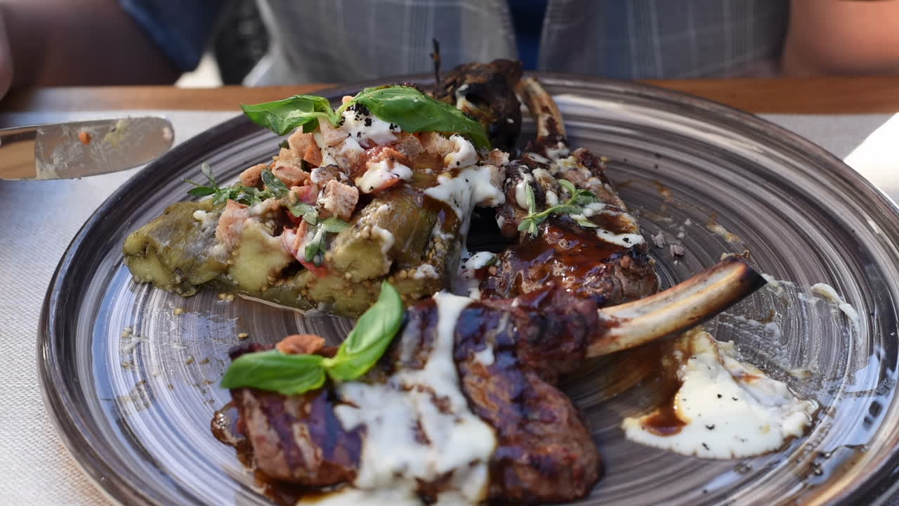 Close up of a woman eating ribs with vegetables at a terrace