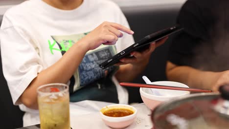 personas que usan una tableta para pedir comida