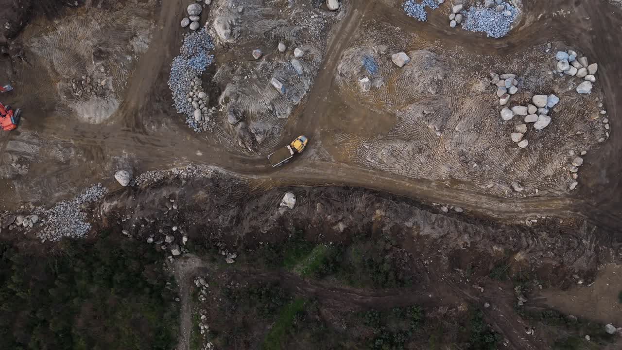 Aerial dump truck on dirt path in rocky construction site in Portugal