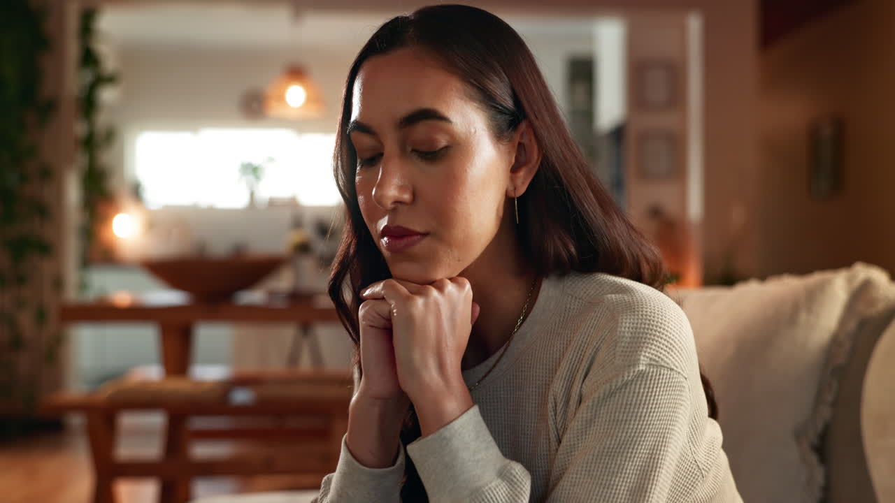 mujer sentada pensativa en un sofá