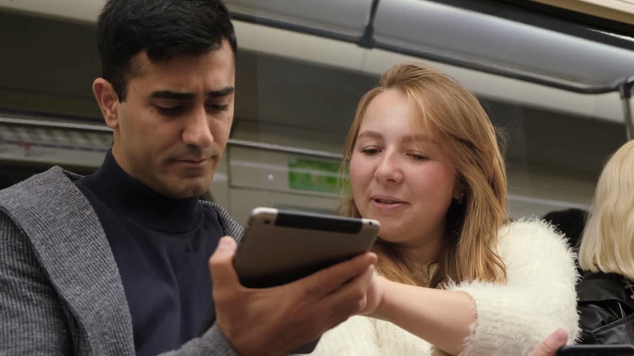 dos personas usando una tableta en un tren