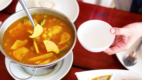 ladling curry into a bowl at a restaurant