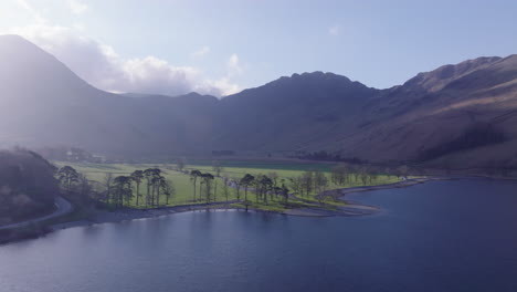 parque nacional de la unesco del distrito de los lagos de buttermere, el amanecer aéreo avanza y se eleva sobre el lago hacia la cabeza del lago y las montañas