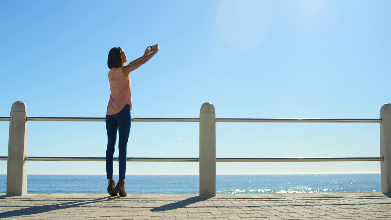 바다 근처의 해가 지는 하늘을  ⁇ 처하는 여자 4k