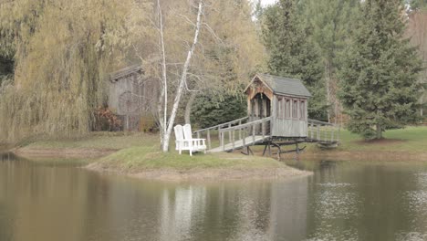 beautiful island in the middle of a pond with a wooden bridge spanning across to it at bean town ranch reception venue