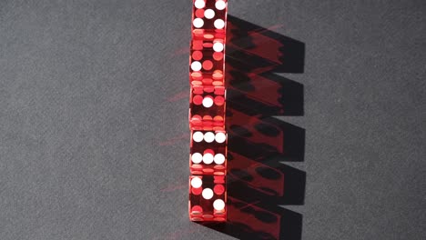 five red craps dice in a row casting a dark red rotating shadow