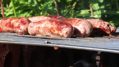 salchichas chisporroteando en primer plano de la barbacoa