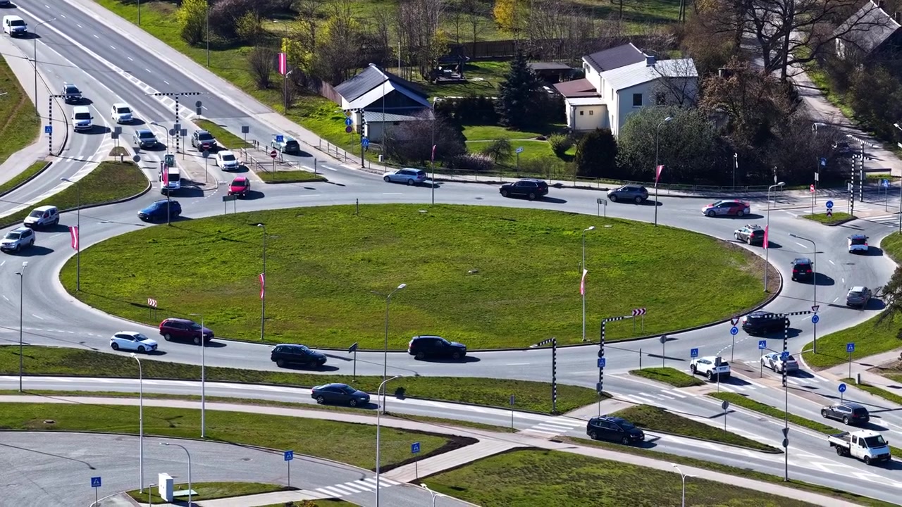 Urban road junction with vehicles driving through a circular intersection in a busy city during rush hour