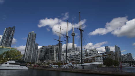 Zeitraffer-Der-Innenstadt-Von-Toronto-Vom-Marina-Quay-Mit-Dem-Ikonischen-Cn-Tower,-Eingerahmt-Zwischen-Den-Masten-Des-Empire-Sanding-Ship