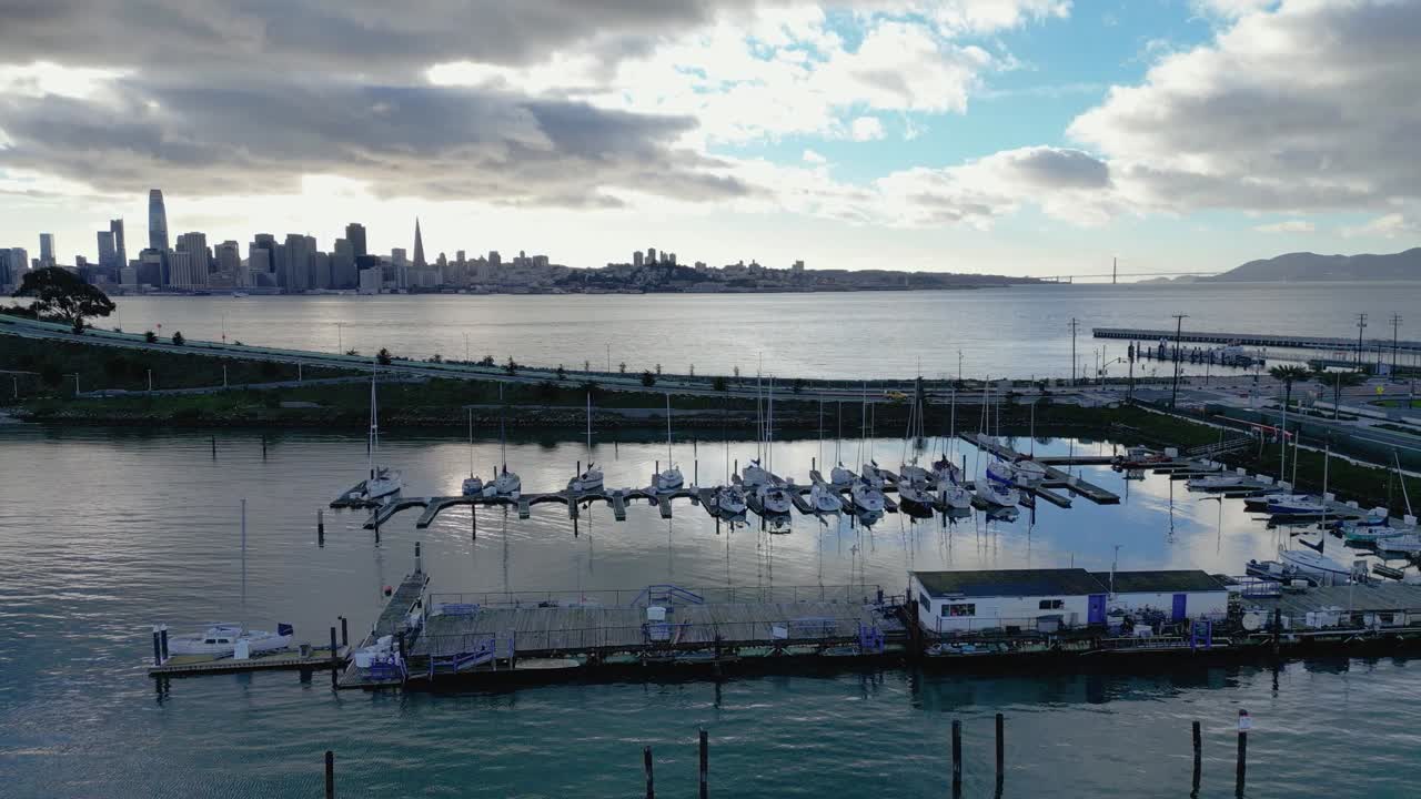 A smooth horizontal side-tracking drone shot of Treasure Isle Marina on Yerba Buena Island, CA. It highlights the marina, boats, and scenic shoreline, perfect for travel, marine, or coastal footage.