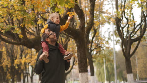 El-Joven-Padre-Y-Su-Pequeño-Hijo-Pasan-Tiempo-Juntos-El-Fin-De-Semana-En-El-Día-De-Otoño.-El-Niño-Está-Sentado-Sobre-Los-Hombros-De-Un-Retrato-Mediano-De-Papá-En-Un-Paisaje-Pintoresco.