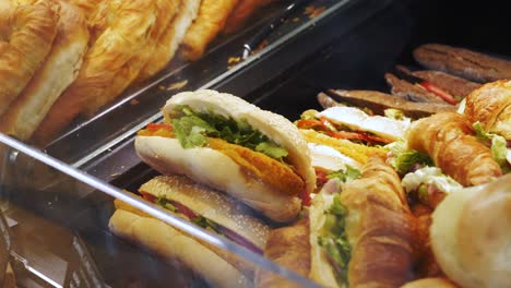 bread and chicken sandwiches displayed behind the window of a local shop