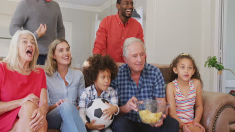 video of diverse family siting on the couch and watching football match