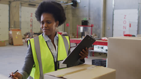 Retrato-De-Una-Trabajadora-Afroamericana-Con-Traje-De-Seguridad-Y-Sonriendo-En-El-Almacén