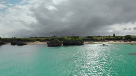 Scenic-rocky-coastline-with-lush-fields-and-dark-clouds-in-the-background