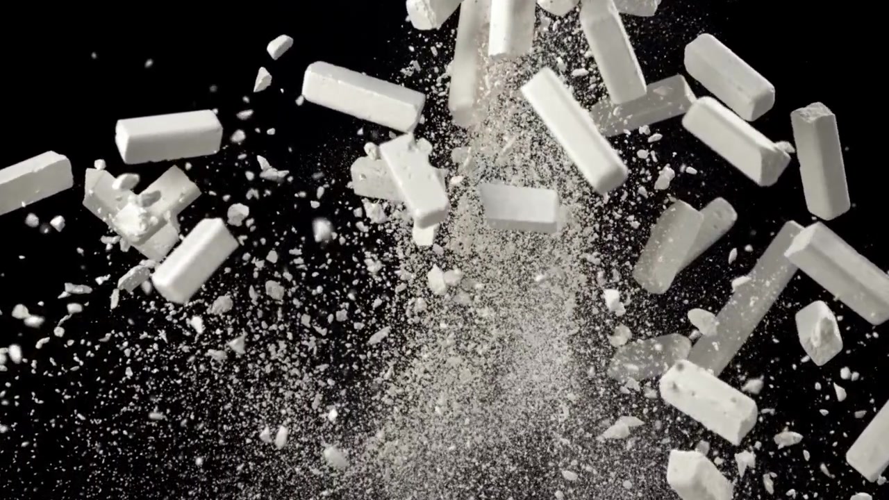 Slow Motion White Chalk Sticks Breaking and Exploding into Dust