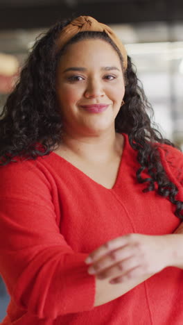 video vertical del retrato de una feliz mujer de negocios biracial en la oficina