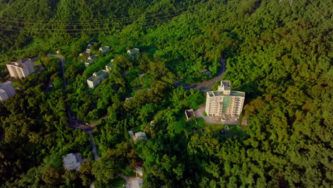 Aerial-View-of-Mountain-Road-and-Buildings-On-Side-of-Hong-Kong-Tallest-Peak-Tai-Mo-Shan-Mountain