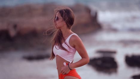 Hermosa-Joven-Está-De-Pie-En-Una-Playa-Y-Posando-En-Una-Cámara