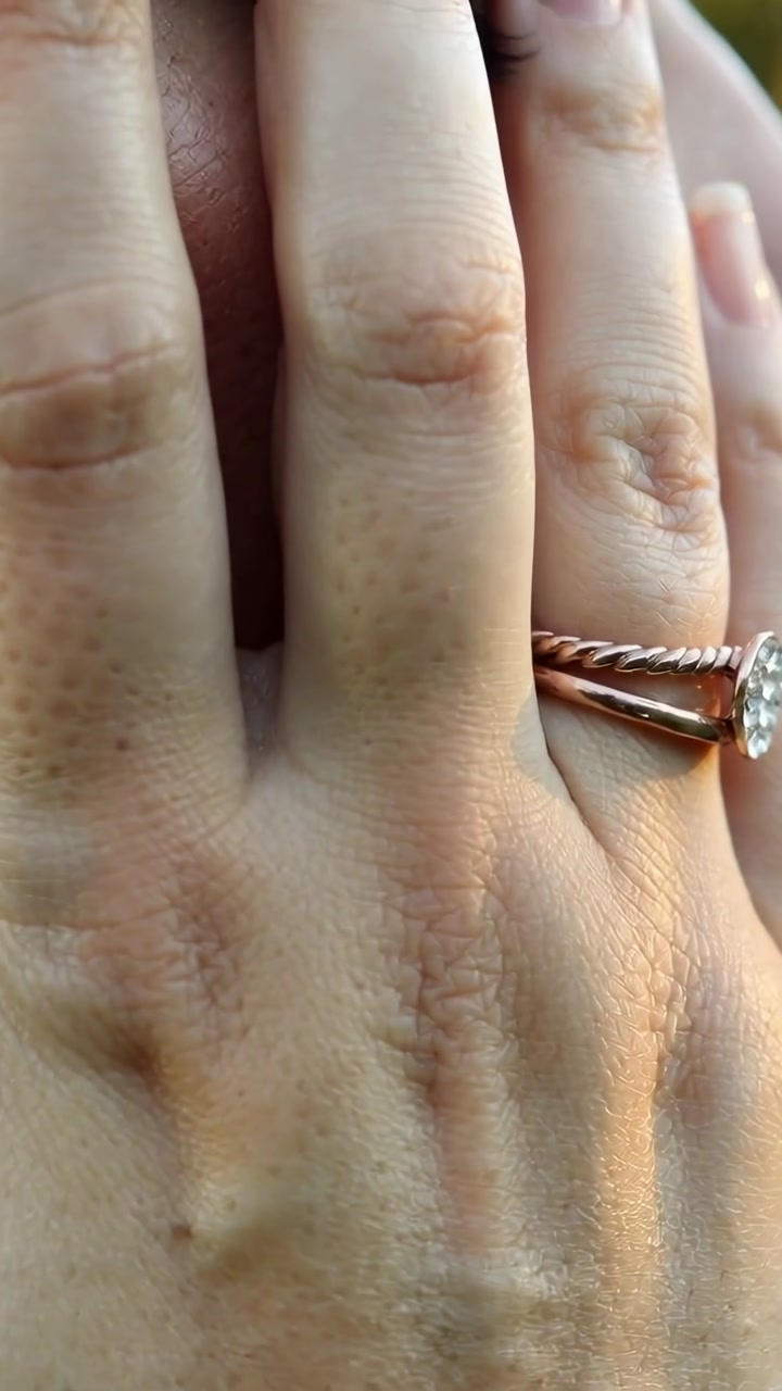 Vertical video: Covering hand shifting with sunlight falling outdoors, showing rope, gem rings, eye