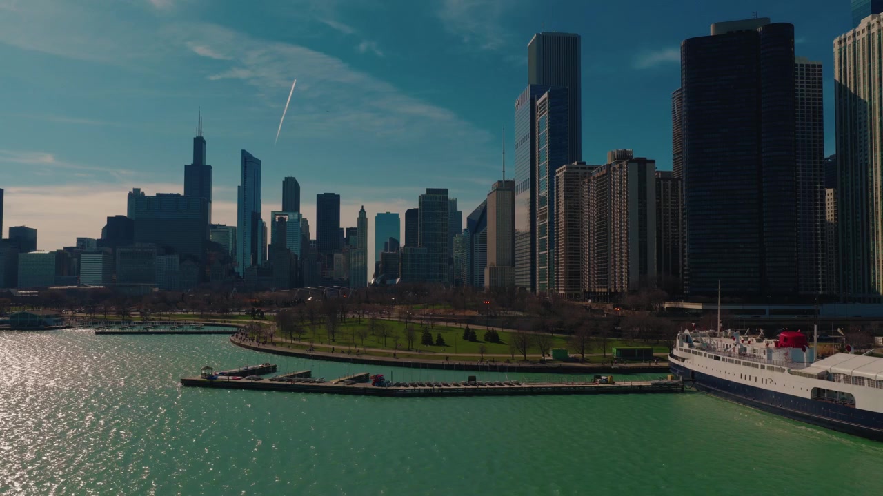 Lungomare di Chicago dall'alto con lo skyline del centro attraverso il Lago Michigan, acqua blu scintillante e un porto turistico sul lago sotto un cielo sereno e soleggiato in Illinois, USA.
