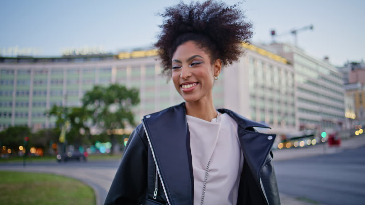 Linda garota andando na rua com close-up do cabelo cacheado ao vento. mulher