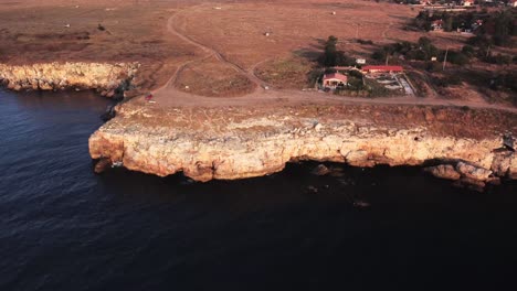 Drone-Vista-Aérea-De-Arriba-Hacia-Abajo-De-Las-Olas-Salpican-Contra-La-Costa-Rocosa,-Fondo