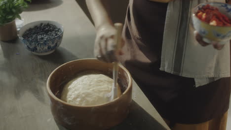 food blogger adding oil to dough