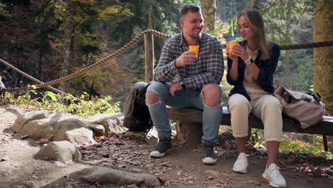 couple enjoying drinks in autumn forest