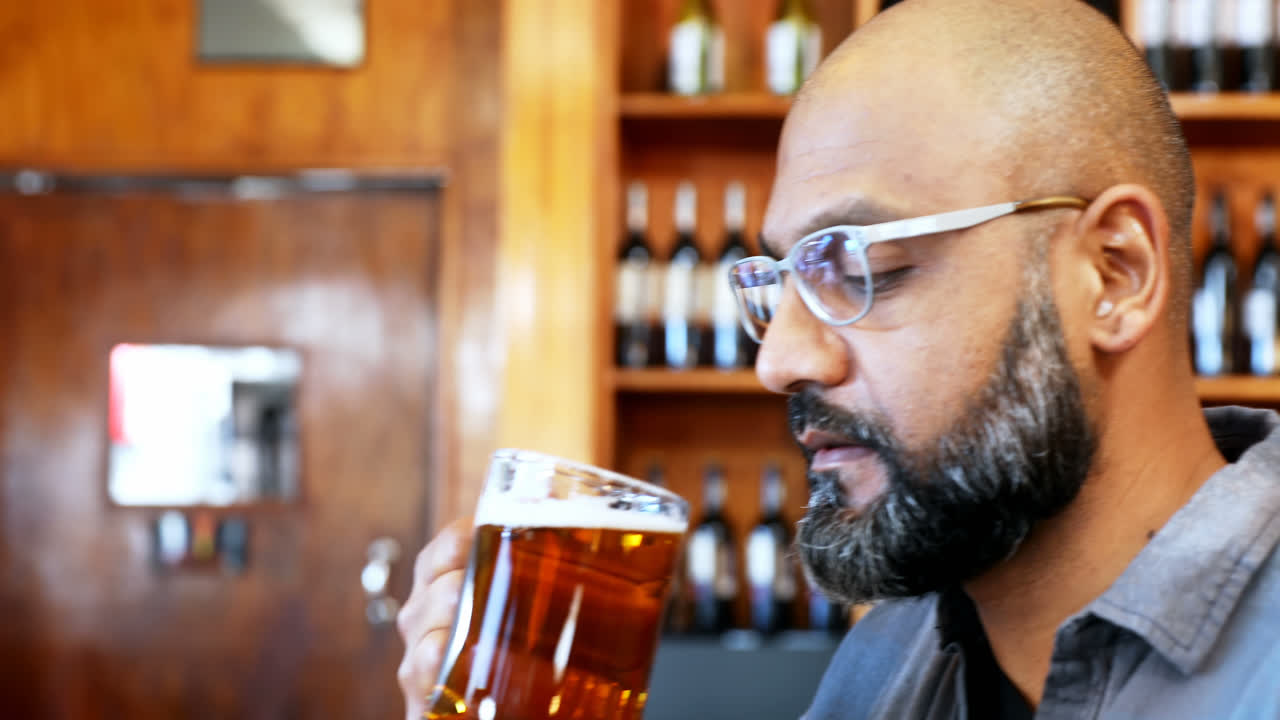 Man having glass of beer in restaurant 4k