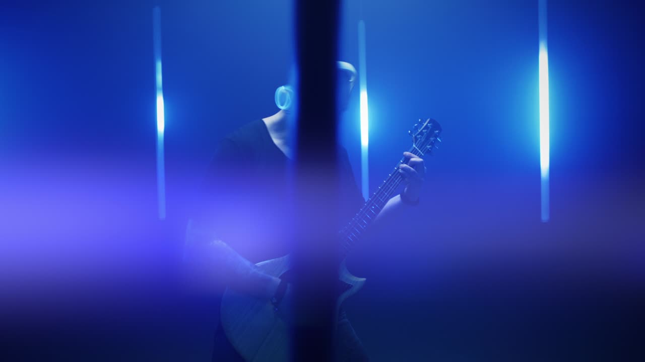 músico enérgico tocando la guitarra en medio de las luces azules