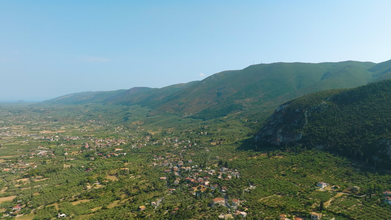 Aerial view of a Greek village nestled in a valley with mountains