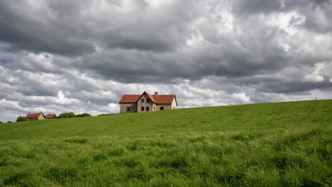 old farmhouse in a green field under cloudy sky