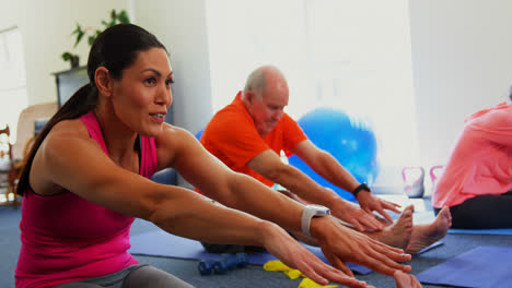 Side-view-of-Caucasian-female-trainer-training-senior-man-in-exercising-at-fitness-studio-4k