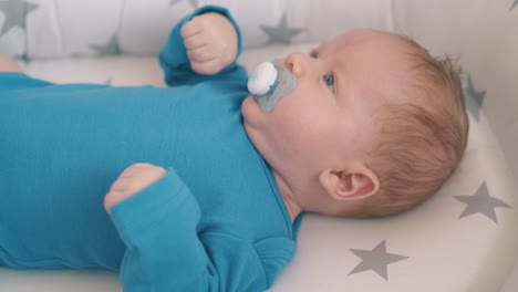 niño lindo con muñeco se encuentra en un capullo de sueño suave en la cuna