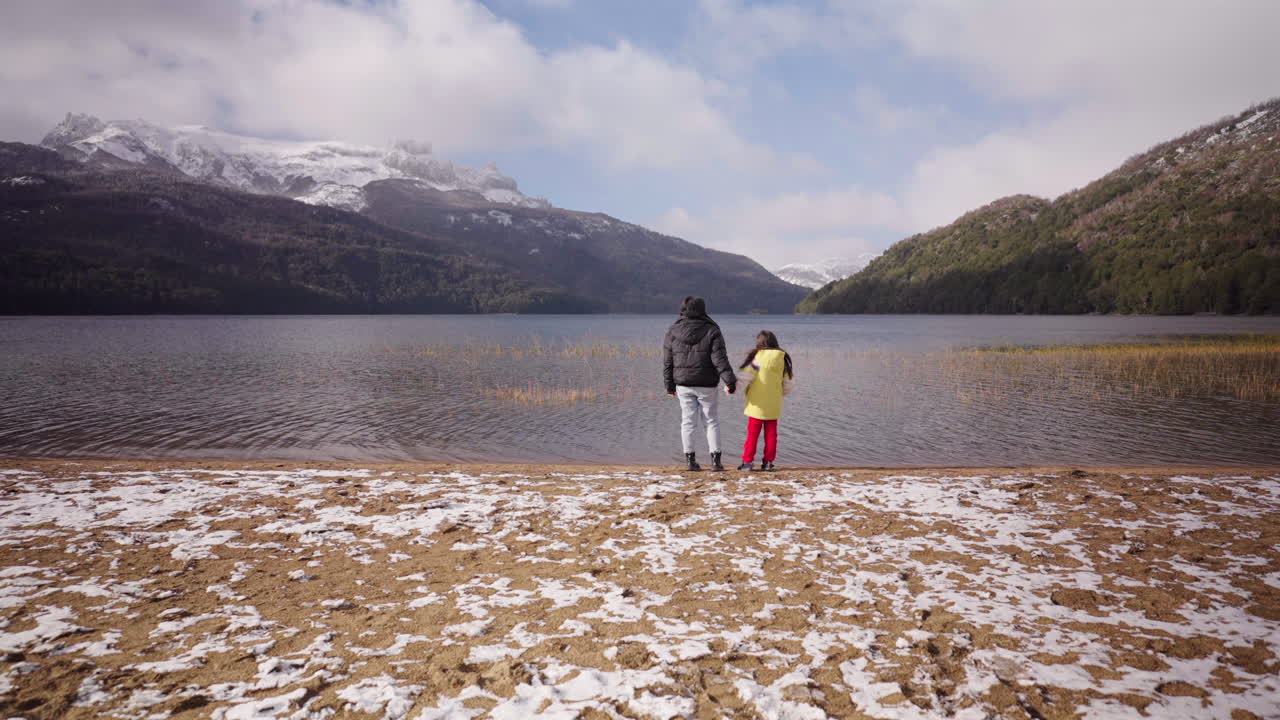 Adult and child hugs each other on meeting point, Lago Falkner, Neuquén, Argentina