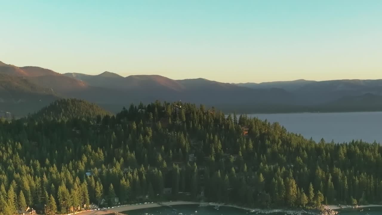 Travel views of Lake Tahoe with surrounding trees and mountains at sunset