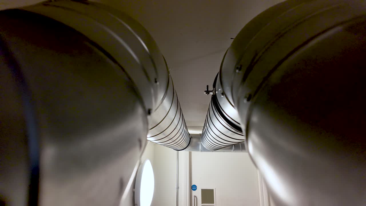 Metal Ductwork Pipes in Office Basement Ceiling Pair of Industrial Ventilation System Components Silver Metallic Finish Interior View Building Infrastructure