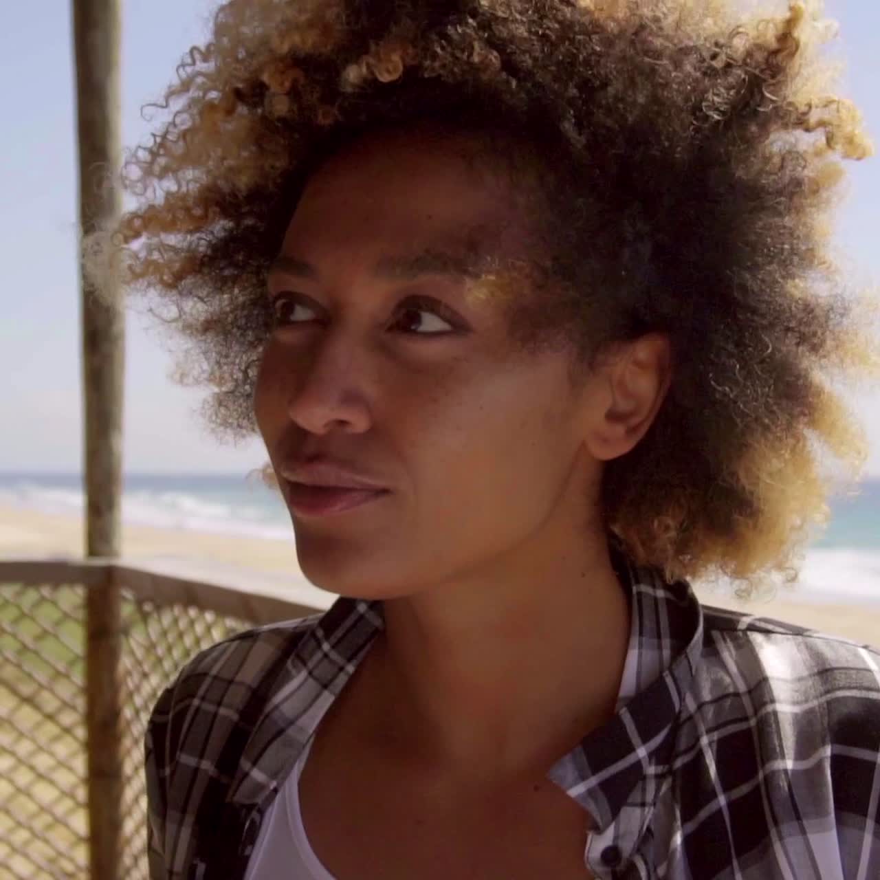 Adorable afro girl sitting in beach bar