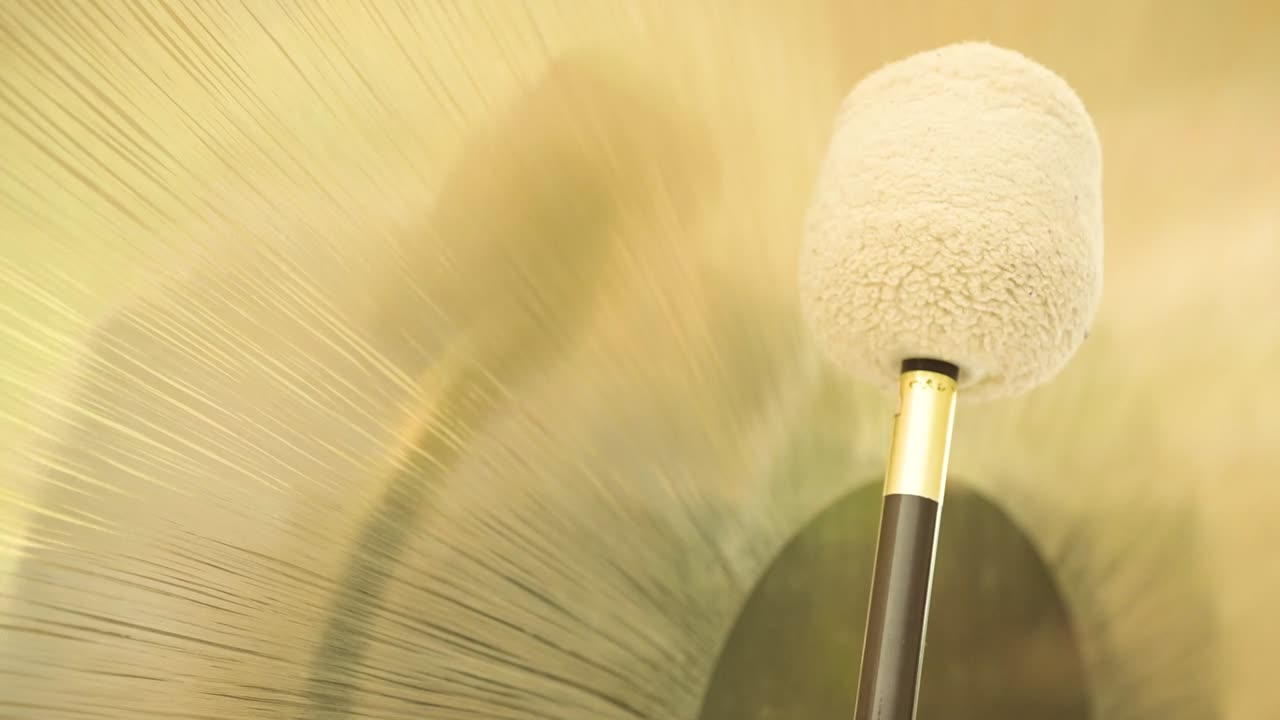 Crop spiritual practitioner with hammer playing gong