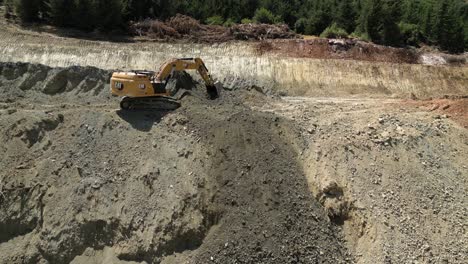 excavator digging up the earth and destroying the forest to make room for building a road