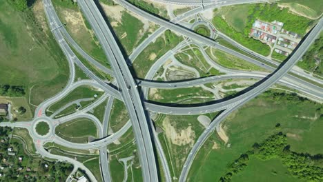 aerial static drone footage capturing intricate highway junction with cars navigating complex roundabouts and intersecting roads with cars