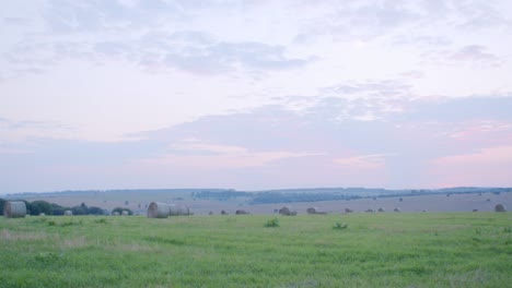 scenic sunset over hay rolls in field. agriculture field with sky.