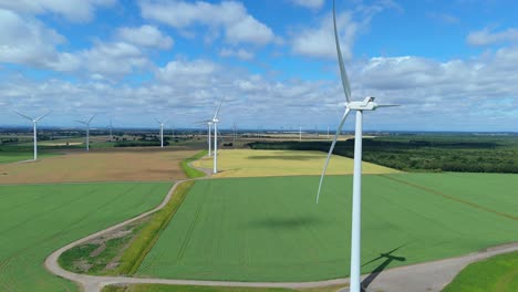 sunny day wind turbine electricity production in english fields drone footage