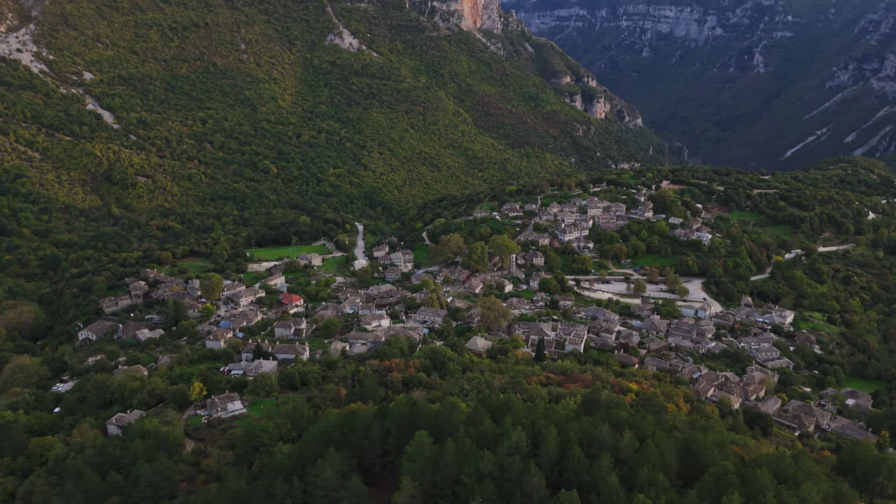 Aerial establishing view of Papigo village with surrounding forests and mountains under soft twilight lighting