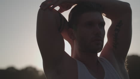 Close-Up-Shot-of-Man-Stretched-In-Park-Before-He-Works-Out-Whilst-Being-Back-Lite-By-The-Sun---Ungraded