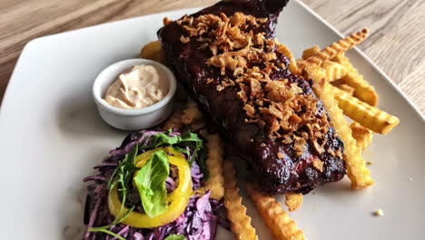 tasty steak with savory sauce, crispy fries, and fresh salad served on a restaurant plate.